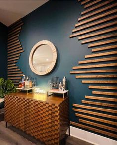 a room with blue walls and a wooden counter in front of a round mirror on the wall