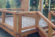 a wooden deck with metal railings next to a house