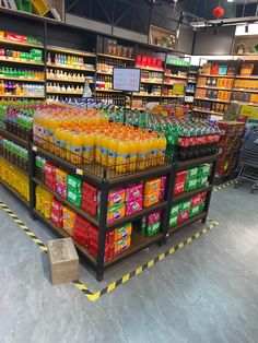 a grocery store filled with lots of orange and yellow drinks on top of shelves next to each other