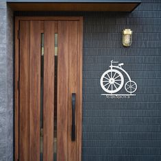 a wooden door with a bicycle decal on the wall next to it's entrance