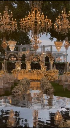 an outdoor wedding venue with chandeliers and chairs