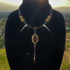 Handmade and one-of-a-kind 12-17" adjustable necklace. Includes two 925 silver spikes, gold and copper accents, three colors of czech glass beads, and African carved bone beads. Has a copper archangel hangdown charm attached to the end of the closure.  Inspired by vampires, covens, blood, and royalty.  No necklaces from this shop are ever duplicated. Bloodstone Necklace, Vampire Queen, Carved Bone, Copper Accents, Bone Beads, Bone Carving, Adjustable Necklace, Czech Glass Beads, Czech Glass