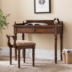 a wooden desk with a chair next to it and a potted plant in the corner