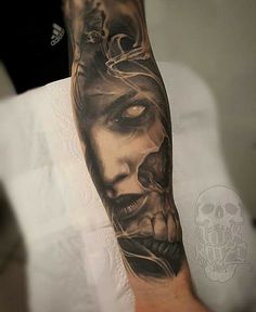 a man's arm with a black and grey tattoo on it