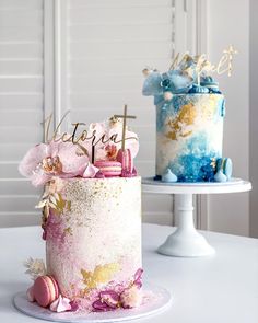 two cakes decorated with pink, blue and gold frosting