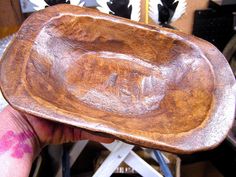 a person holding a wooden bowl in their hand