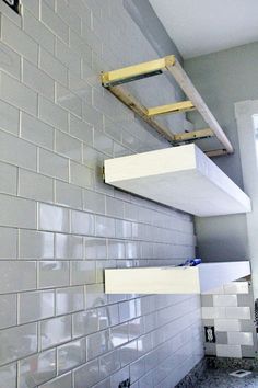 a white tiled wall with some shelves on it