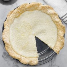 a pie sitting on top of a metal pan with a slice missing from it's crust