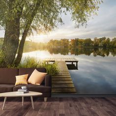 a couch sitting on top of a wooden floor next to a wall covered in trees