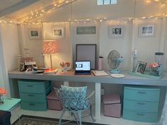 a desk with several drawers and lights on the wall above it is decorated in pastel colors