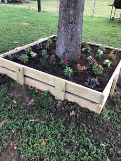 a wooden planter box sitting under a tree