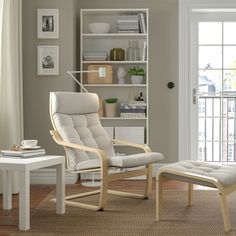 a living room with a chair, ottoman and book shelf in it's corner