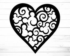 a heart shaped cutout with swirls and hearts on white wood planks, ready to be used as a stencil