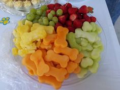 there are many different types of fruit on the plate and one has a dog shaped cut out