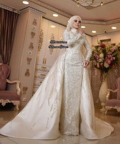 a woman in a white wedding dress posing for the camera