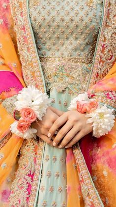 a close up of a person wearing a dress with flowers in their hands and holding onto the