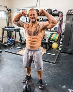 a shirtless man standing in a gym