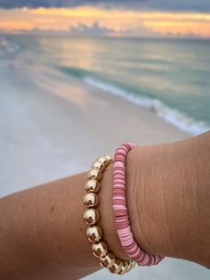 This is stack with a heishi bead bracelet and a fashion gold toned beaded bracelet. This is perfect for birthday gifts, party favors, bridal showers, weddings, baby showers, or even Christmas! You can select the size of these bracelets.  7 inches is the standard size for women and 8 inches for men This bracelet doesn't come with a clasp. If you want them with clasps, message me and I'll make a custom listing for you. It will cost extra to do a clasp.  If you need a larger quantity message me and we'll work something out.  If you have any problems purchasing anything from me message me and I'll try my best to make your purchase as smooth as possible.  Thank you, Chloe. Gold Heishi Beads Bracelets For Friendship, Pink Bracelets With Gold Beads For Beach, Gold Stackable Stretch Bracelet For The Beach, Pink Stackable Heishi Beads Bracelets, Gold Stackable Friendship Bracelets For Beach, Pink Heishi Beads Bracelet With Gold Beads, Gold Stretch Bracelet With Round Beads For Beach, Gold Stretch Bracelet For Beach, Hand-strung Gold Stretch Bracelet For Beach