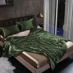 a bed with green sheets and pillows in a room