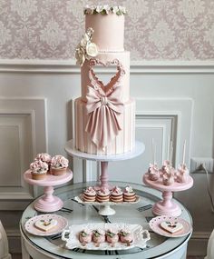 a table topped with pink cakes and cupcakes