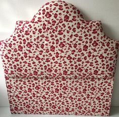 a red and white leopard print headboard made out of cardboard with an open top