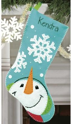 a christmas stocking hanging from a tree with snowflakes on it's head