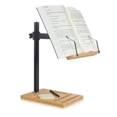 an open book sitting on top of a wooden stand