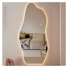 a mirror that is on the side of a wall next to a chair and couch