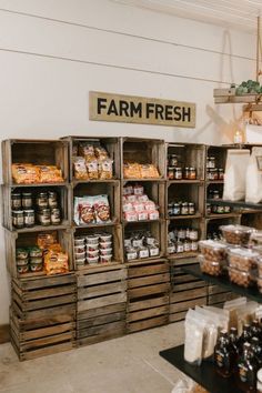 the inside of a farm fresh store with lots of food in wooden crates on display