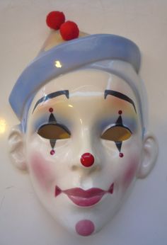 a close up of a clown's face wearing a hat