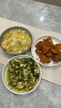 three bowls of food are sitting on a table