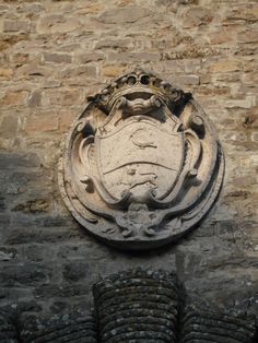 a stone wall with a coat of arms on it