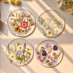 four glass plates with flowers painted on them