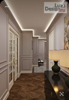 an empty hallway with white walls and wood flooring is lit by recessed lighting