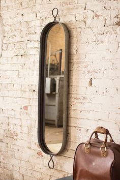 two suitcases and a mirror on a brick wall