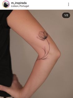 a woman's arm with a tattoo that has a flower on the back of it