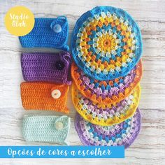 several crocheted hats are stacked on top of each other and one has a button in the middle