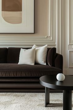 a living room with a brown couch and white pillows