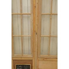 an old wooden double door with glass panels and chalkboard on the outside side, in front of a white background