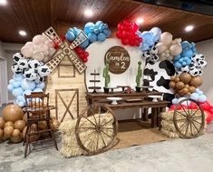 a decorated stage with balloons, hay bales and farm animals