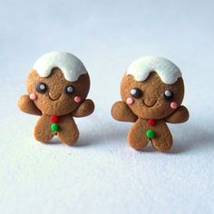 two small gingerbread men with white frosting on their faces and ears are standing next to each other