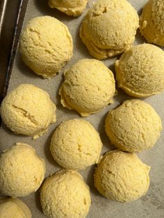 several round yellow pastries on a baking sheet