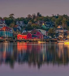 colorful houses are reflected in the still water