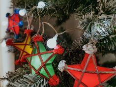 three christmas ornaments hanging from a tree in the shape of stars and an ornament