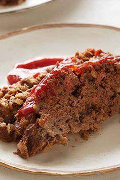 a piece of meatloaf on a plate with ketchup