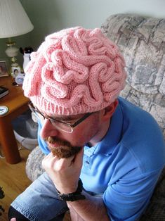 a man wearing a pink knitted brain hat