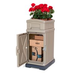 a planter with red flowers in it sitting on top of a carton filled with boxes