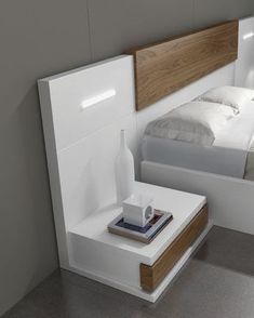 a white bed sitting next to a night stand on top of a gray tiled floor