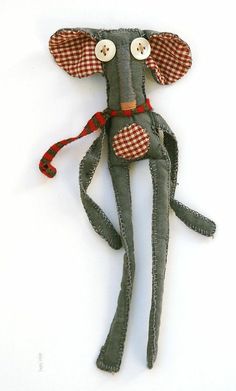 a gray stuffed animal with red and white checkered ears