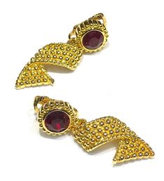 These beautiful vintage Swan signed  Swarovski  earrings features  round faceted red crystal set in to a gold tone.   The dangle is a beaded gold tone ribbon shape and the earrings measure 1.75" L x  .50" and are clips in very good to excellent vintage condition with the crystals in nice condition as well as the gold tone finish.  Signed with the Swan Logo  Shipping prices vary on the weight of item. I do my best to keep shipping costs reasonable. The prices quoted are not trackable and is the least expensive airmail postage for most countries. If you want tracking, the cost will be higher....please drop me an email to find out the tracking rates as they are priced by weight and destination. Thank you for visiting and shopping at SilentWhisperVintage! Crystal Texture, Vintage Swan, Swan Logo, Crystal Set, Swarovski Earrings, Red Crystals, Etsy Earrings Dangle, Swarovski Crystal, Clip On Earrings